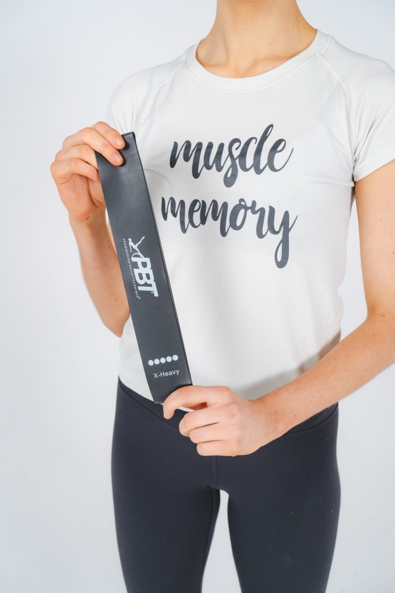 Hand holding black PBT mini-loop resistance band from five-pack set