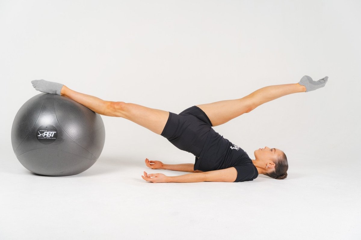 Dancer using PBT ball against wall for balance drill